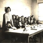 Enseignante pose avec sa classe dans la salle [Histoire de l'école Sainte Croix, Noisy-le-Sec]