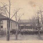 élèves de l'école posant dans la cour derrière les arbres [Histoire de l'école Sainte Croix, Noisy-le-Sec]
